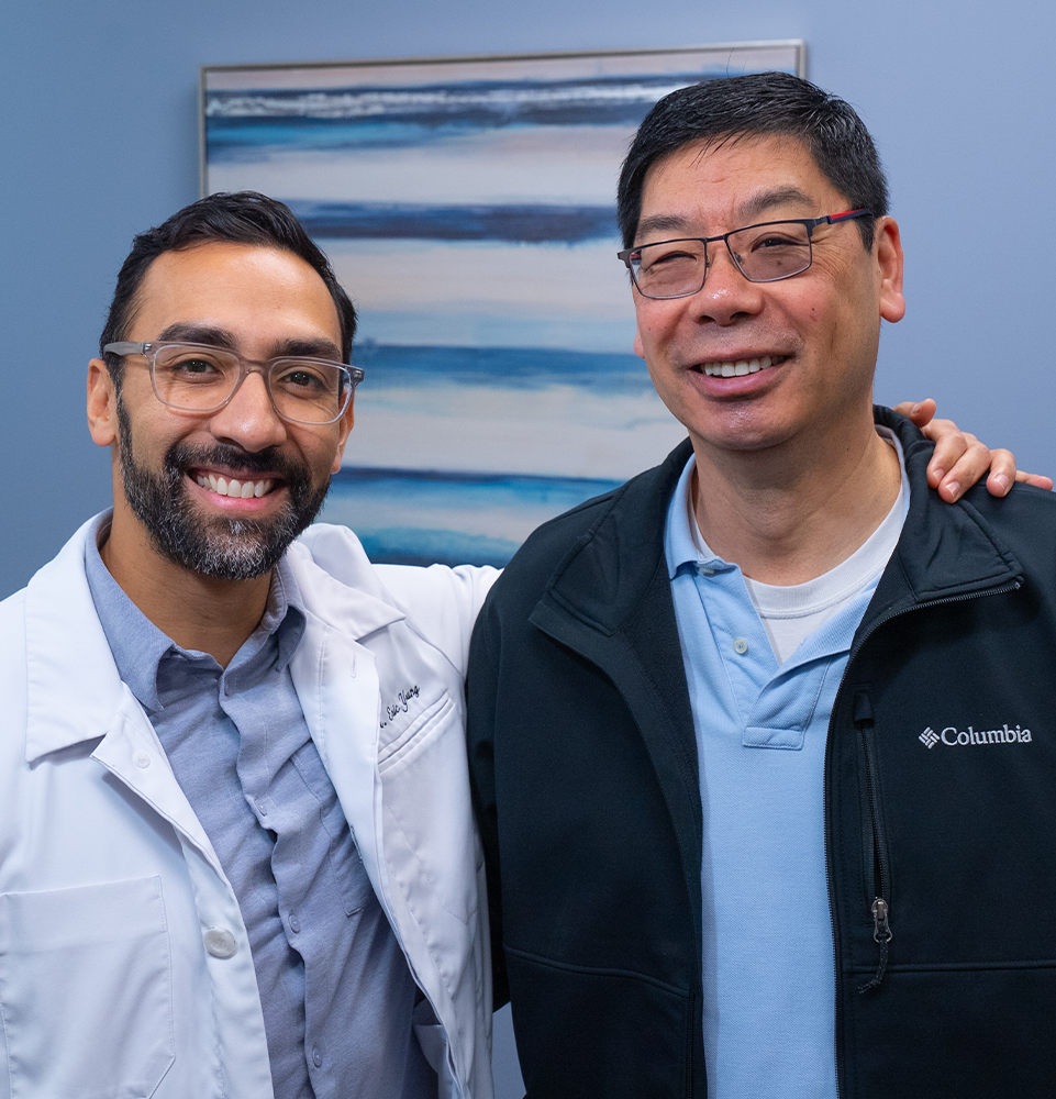 Dr. Young and patient smiling together in the office