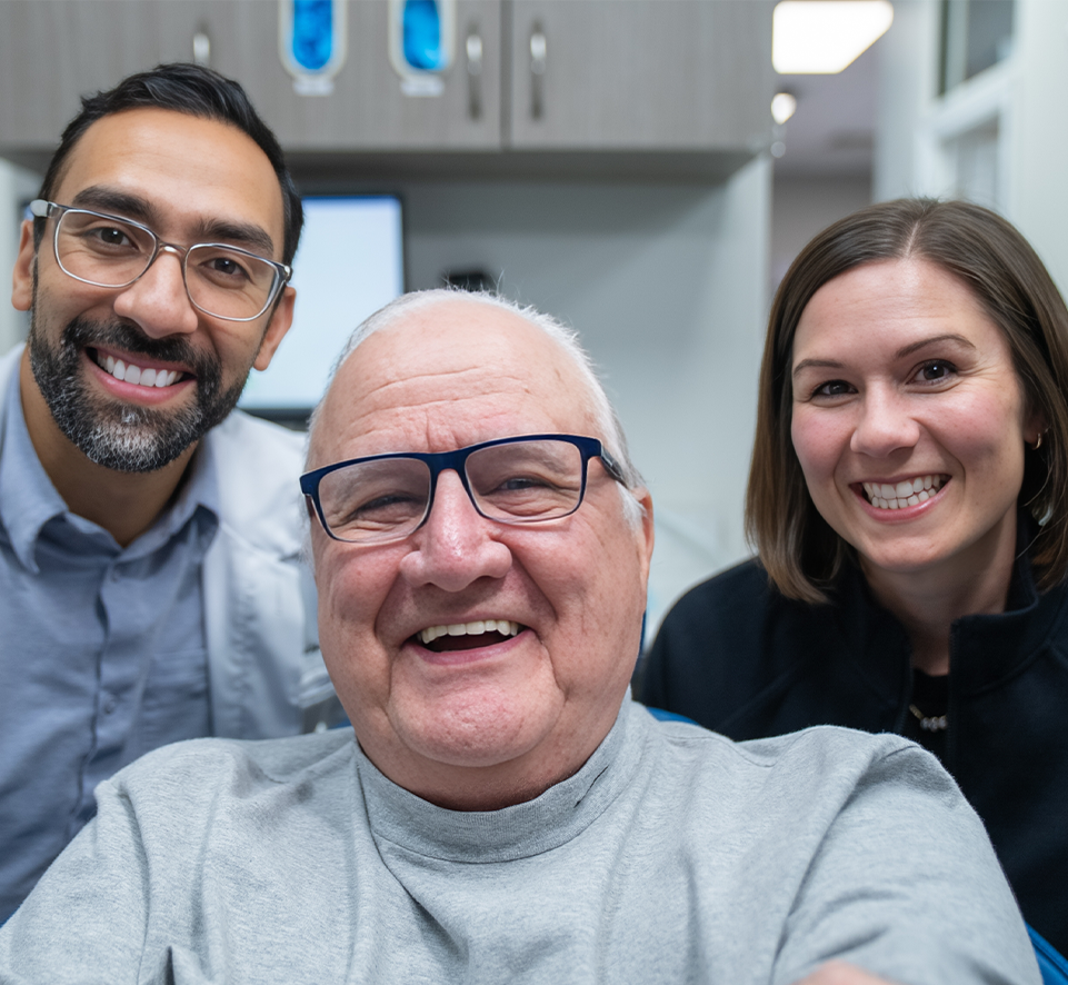 Dr. Young, staff member and patient smiling